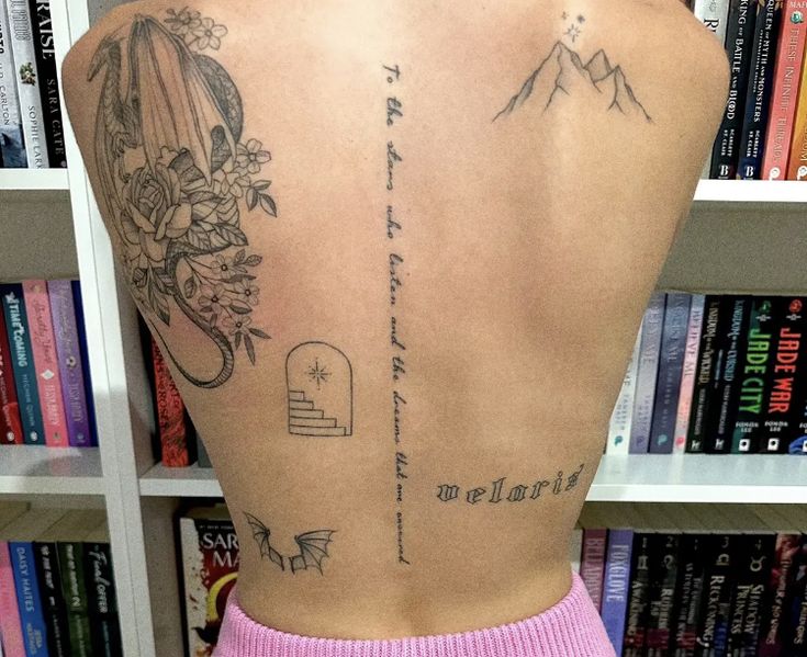 the back of a woman's body with tattoos on it