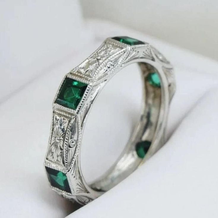 a white gold ring with emeralds and diamonds