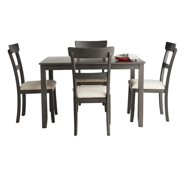 a dining table with four chairs next to each other and an empty plate on the table