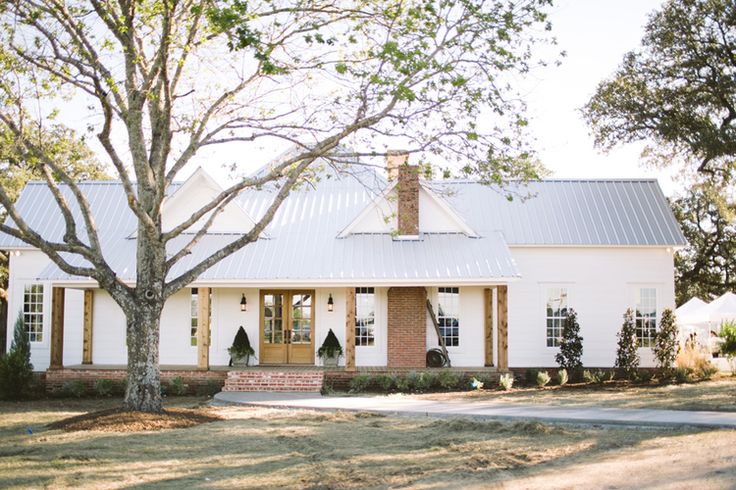 a white house with a tree in front of it