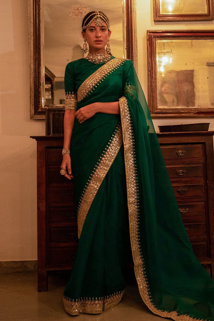 a woman in a green and gold sari