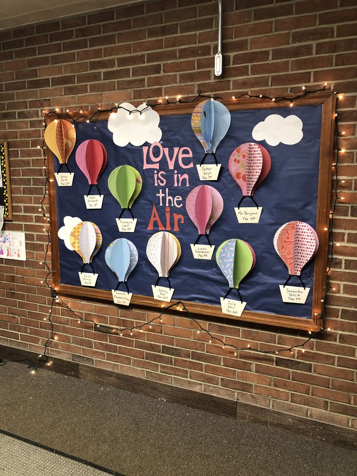 a bulletin board with hot air balloons and love is in the air written on it