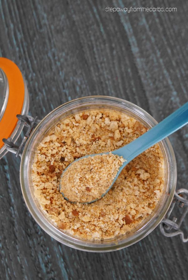 a glass jar filled with breadcrumbs next to an orange and blue spoon