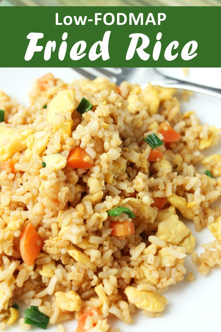 fried rice with carrots and green onions on a white plate