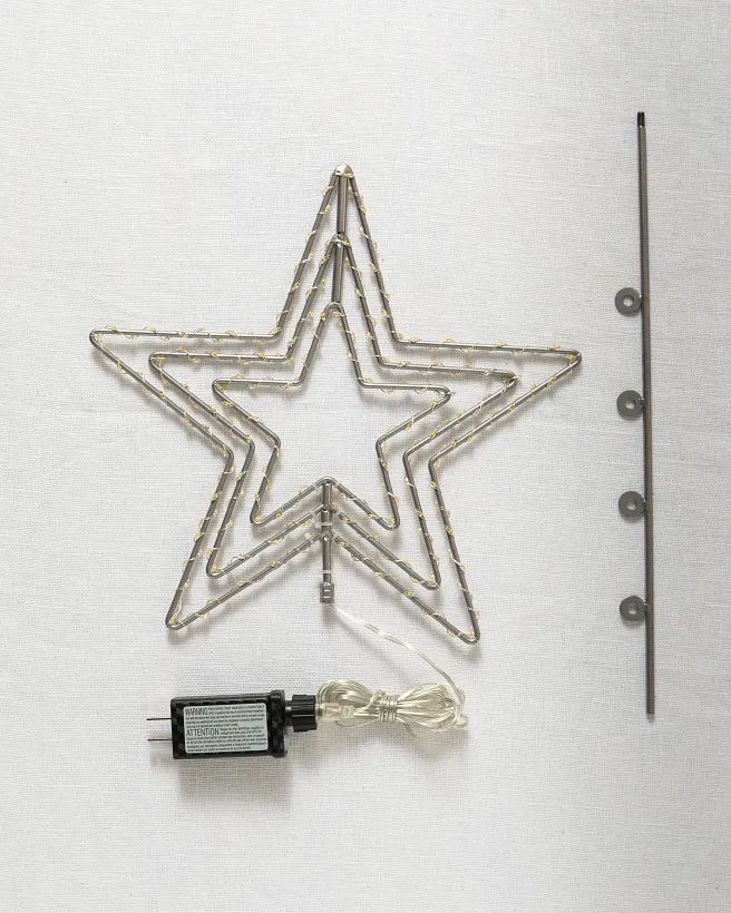 a wire star ornament is attached to a wall