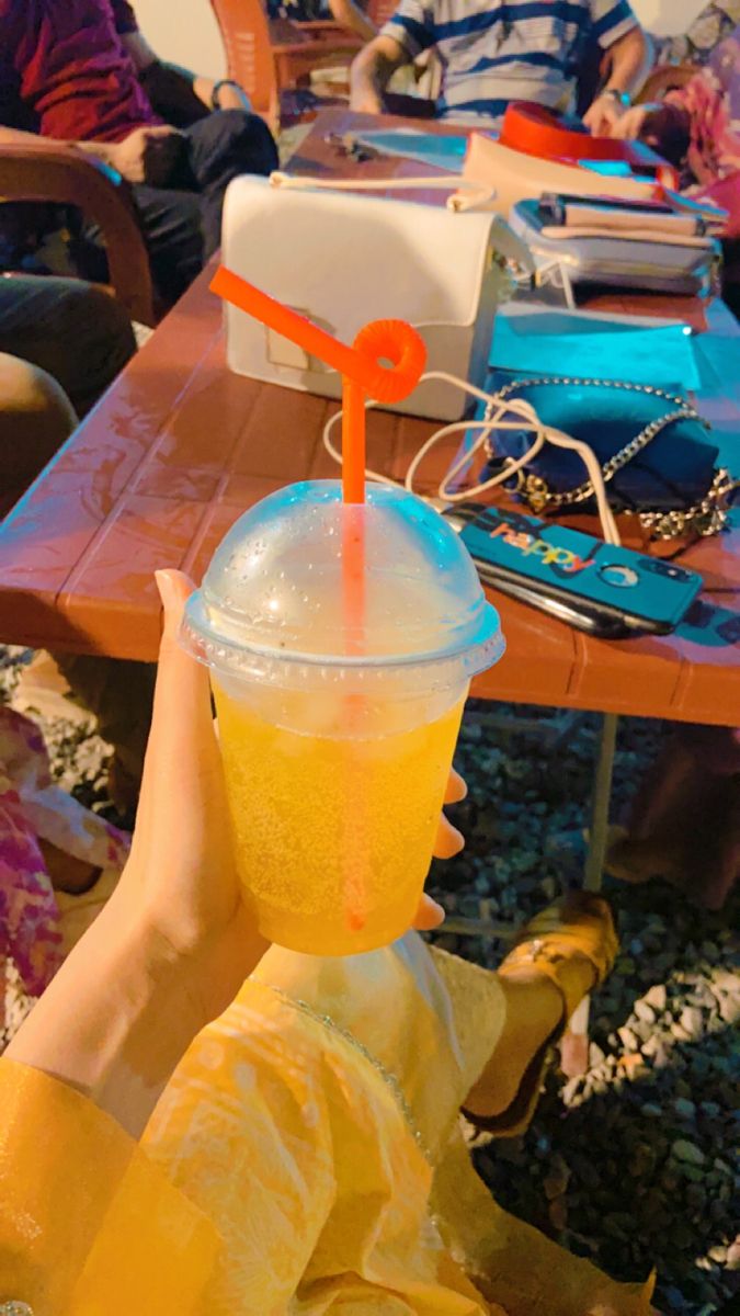 a plastic cup with a straw in it sitting on top of a person's head