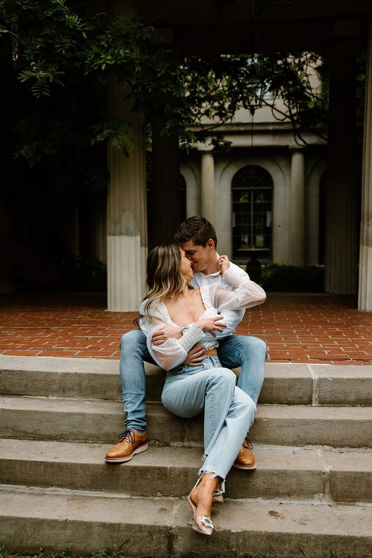 a man and woman sitting on steps kissing