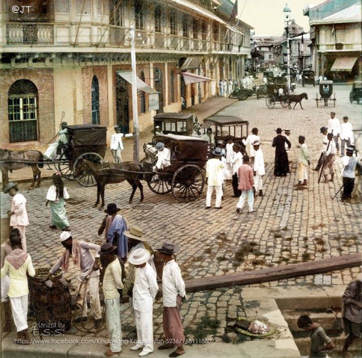 an old time photo of people and horses on the street in front of some buildings