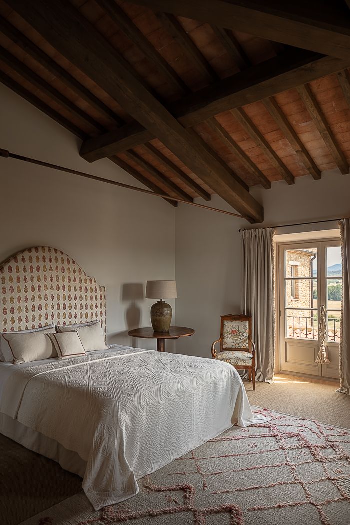 a bedroom with a large bed and two lamps on either side of the bed, in front of a sliding glass door