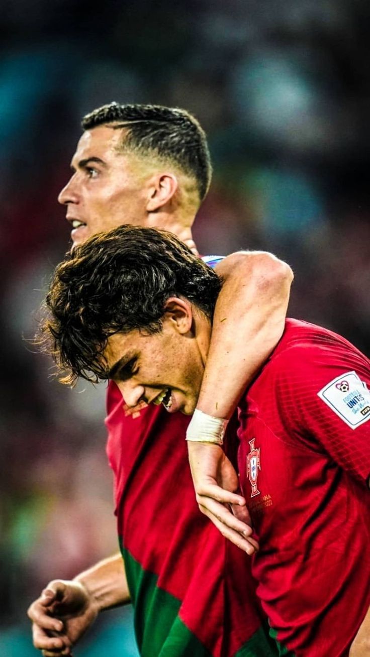 two soccer players are hugging each other in the middle of an intense match between them