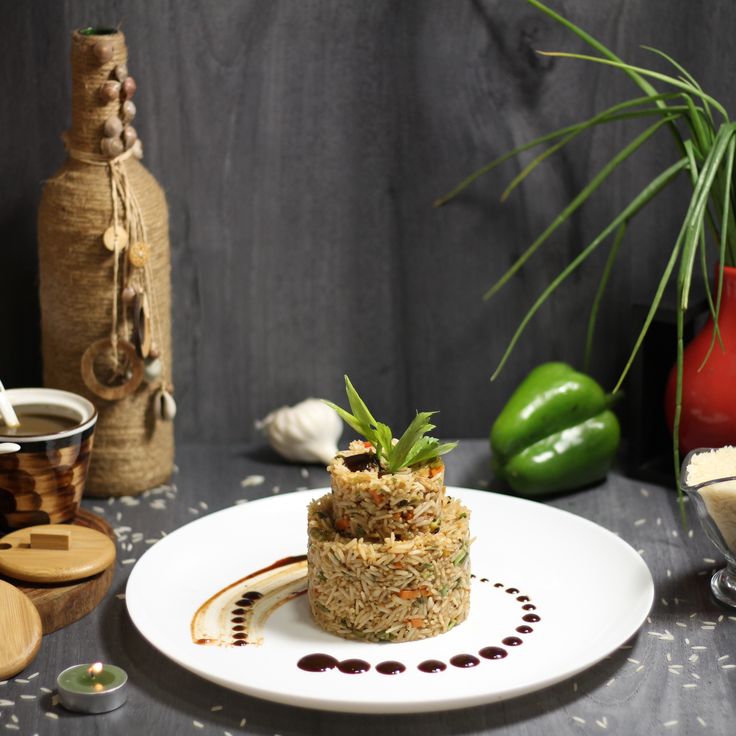 a white plate topped with food on top of a table next to vases filled with flowers