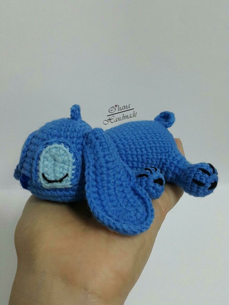 a crocheted blue elephant is held in the palm of someone's hand