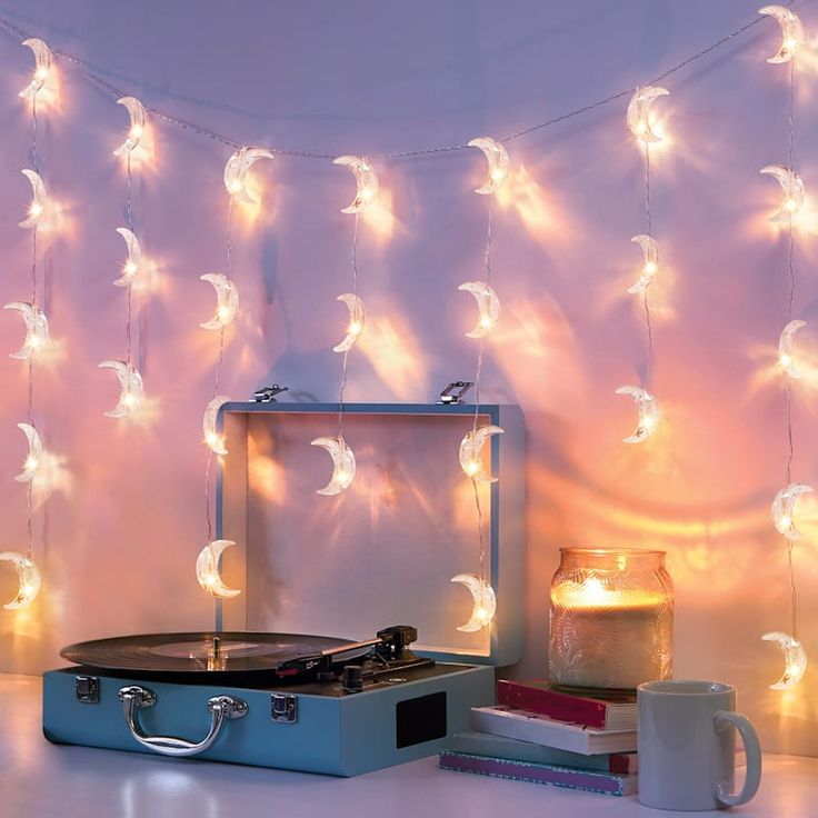 a record player sitting on top of a table next to a candle and some books