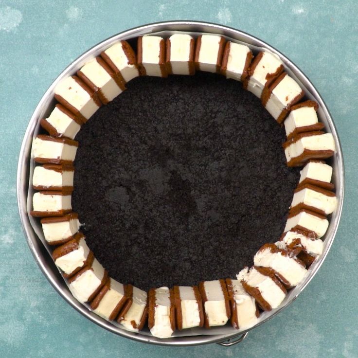 a metal bowl filled with brown and white desserts on top of a blue table