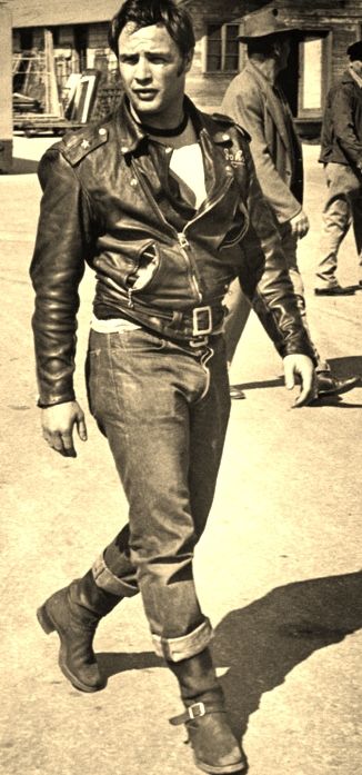 black and white photograph of a man walking down the street in an old fashion leather jacket