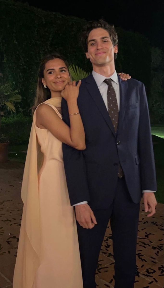 a man in a suit and tie standing next to a woman