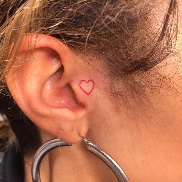 a woman with a heart tattoo on her ear