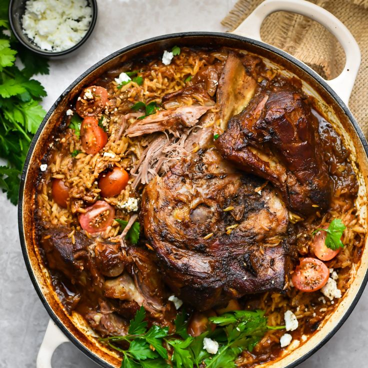 a pan filled with meat covered in sauce and garnished with parsley