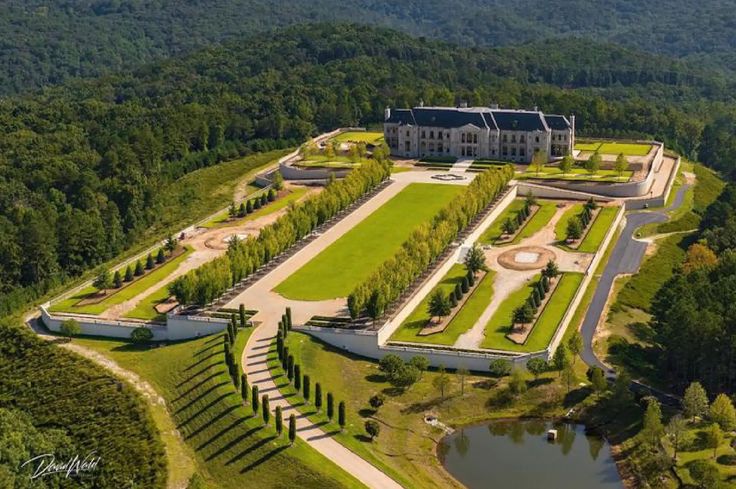 an aerial view of a large mansion surrounded by trees