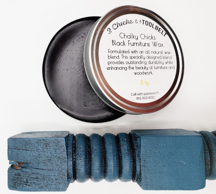 a wooden stick with a tin of black furniture wax on it