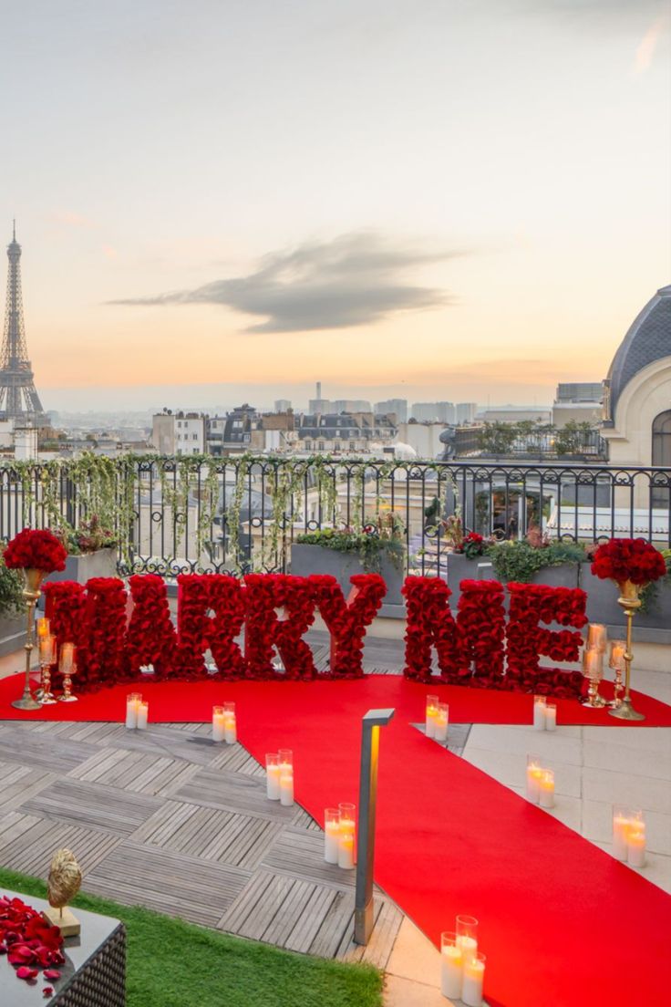 a red carpeted area with candles and flowers in front of the eiffel tower