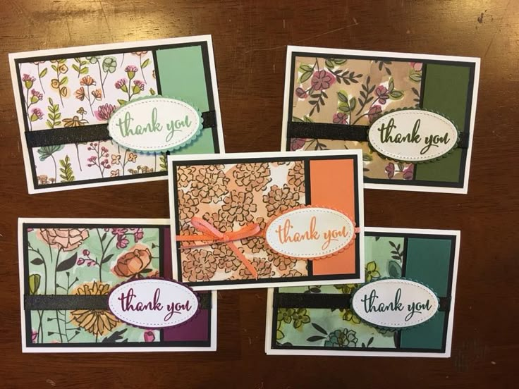 four thank you cards on a table with flowers and ribbons attached to the card holders