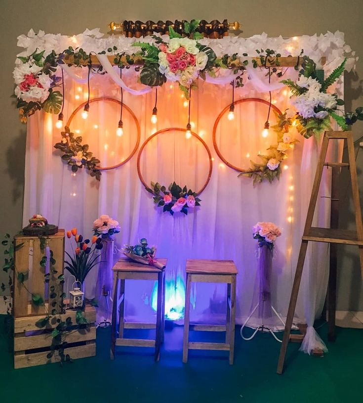 the backdrop is decorated with flowers, lights and wreaths for a wedding or special event