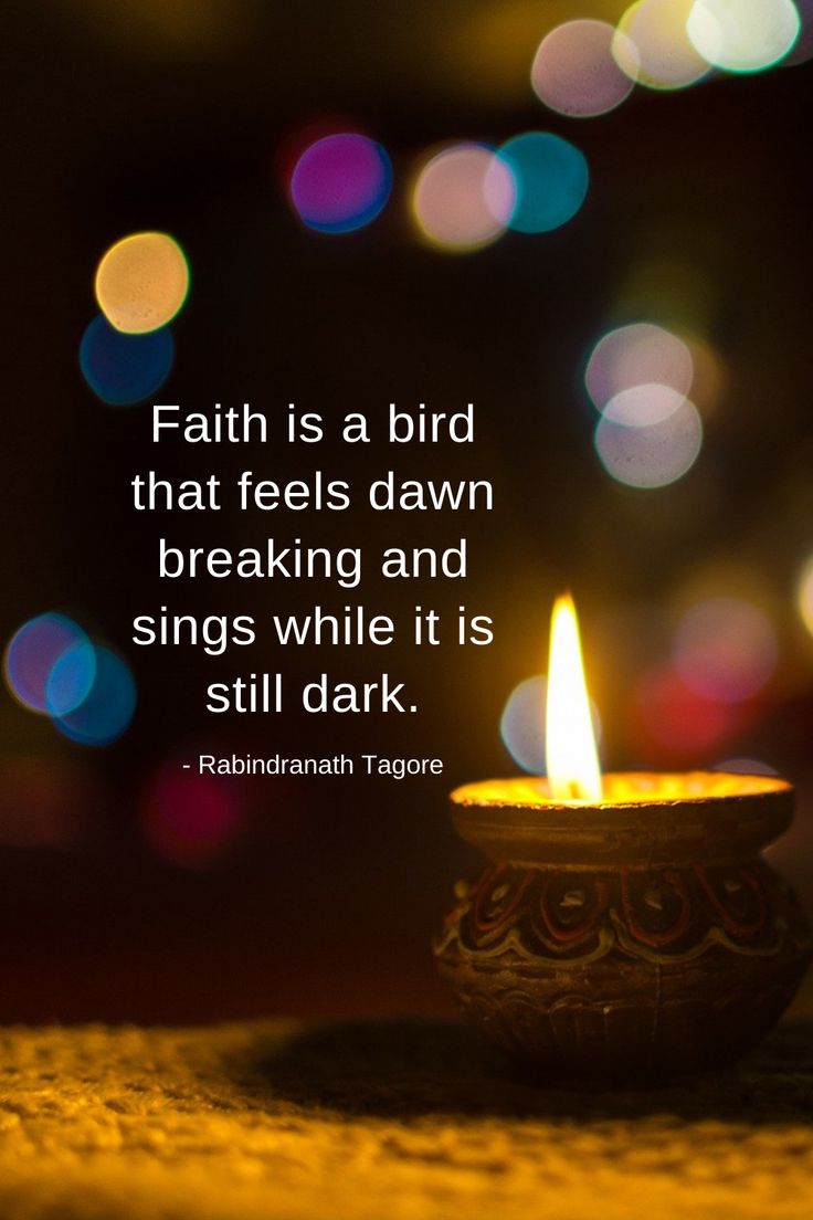 a lit candle with the words faith is a bird that feels dawn breaking and sings while it