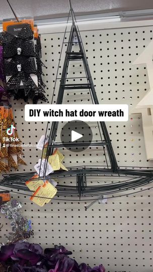 a diy witch hat door wreath hanging on a wall in a store with halloween decorations