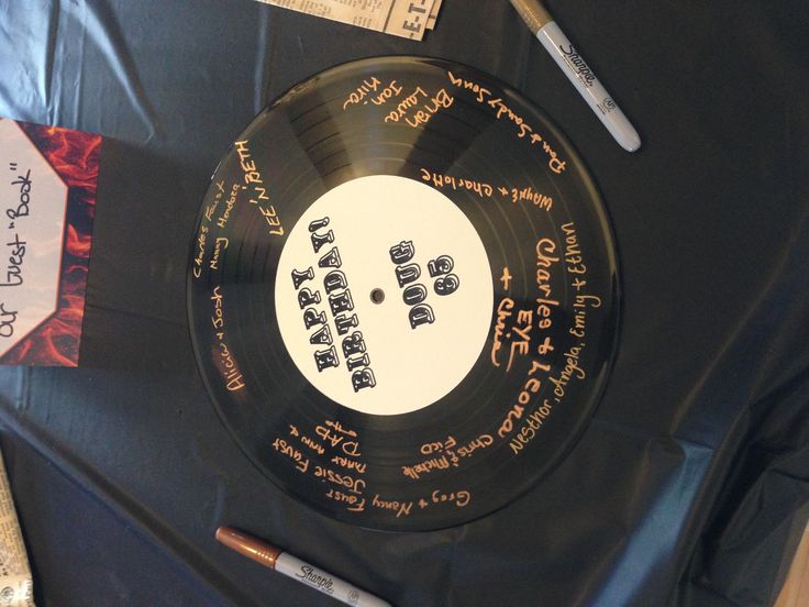 a record with writing on it sitting on a table next to pens and paper tags