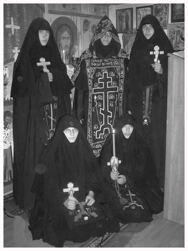 black and white photograph of three women dressed in nun costumes with crosses on their heads