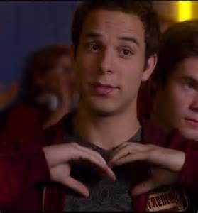 two young men standing next to each other with their hands on their heart shaped fingers