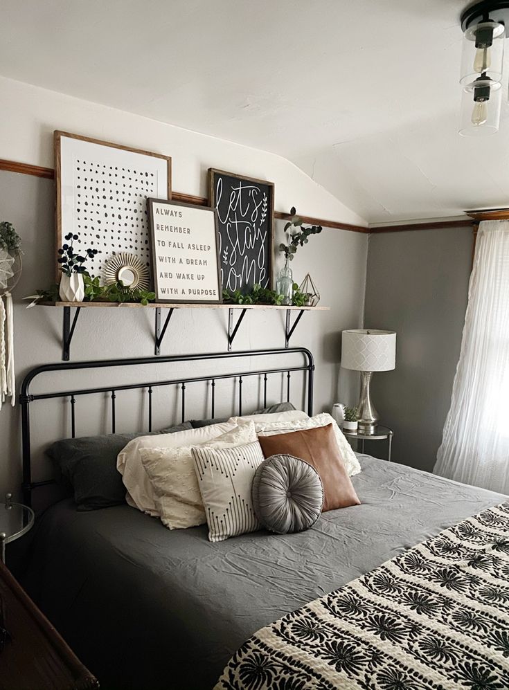 a bed room with a neatly made bed and pictures on the wall