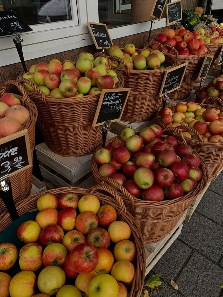 many baskets of apples are on display outside