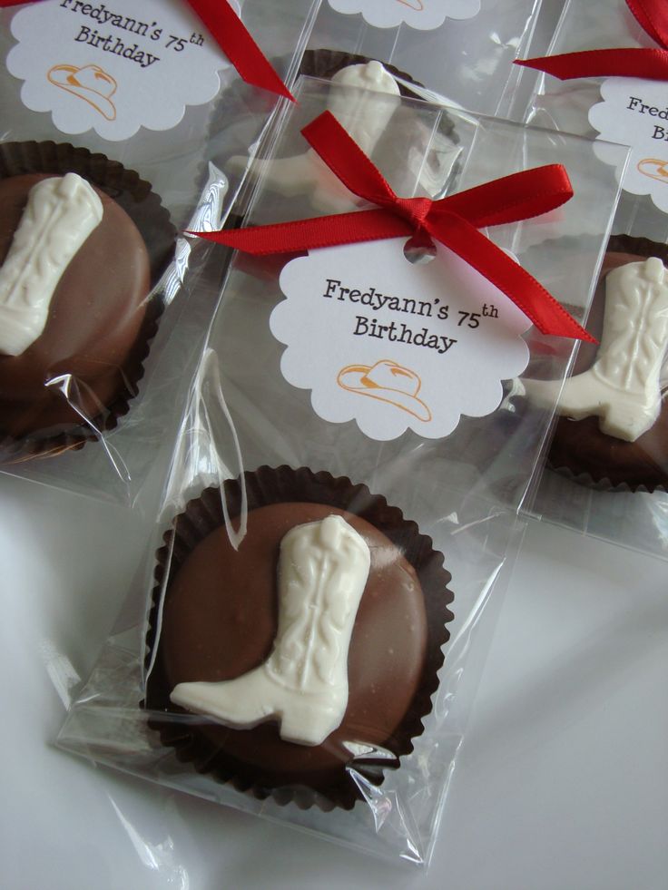 four chocolates wrapped in cellophane and tied with red ribbon