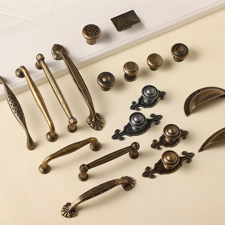 an assortment of door handles and knobs on a white surface