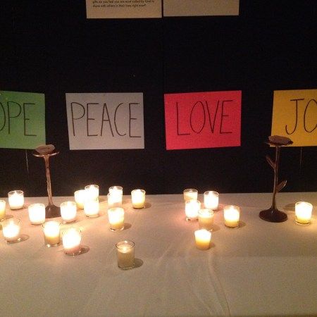 candles sit on a table with signs that say peace, love and joy