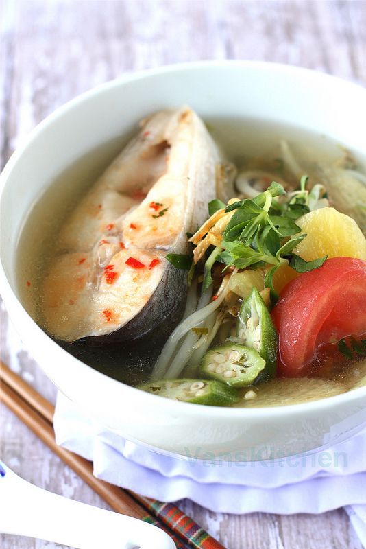 a white bowl filled with soup next to chopsticks