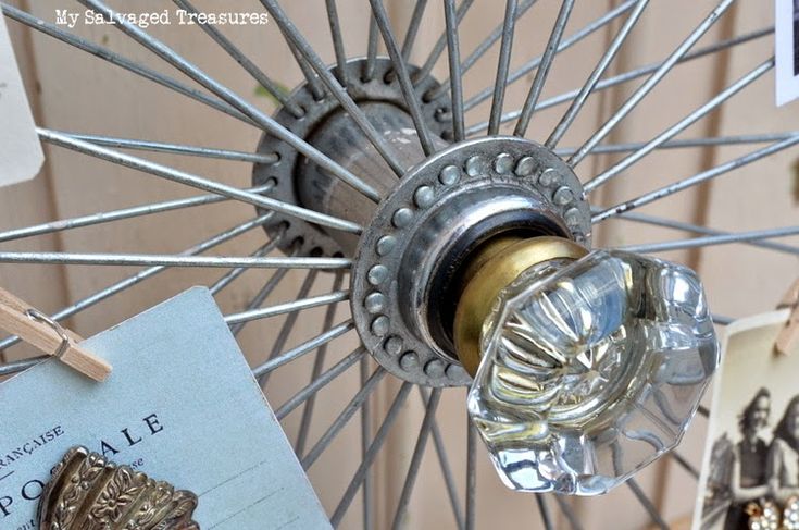 a close up of an old fashioned bicycle wheel with tags hanging from it's spokes