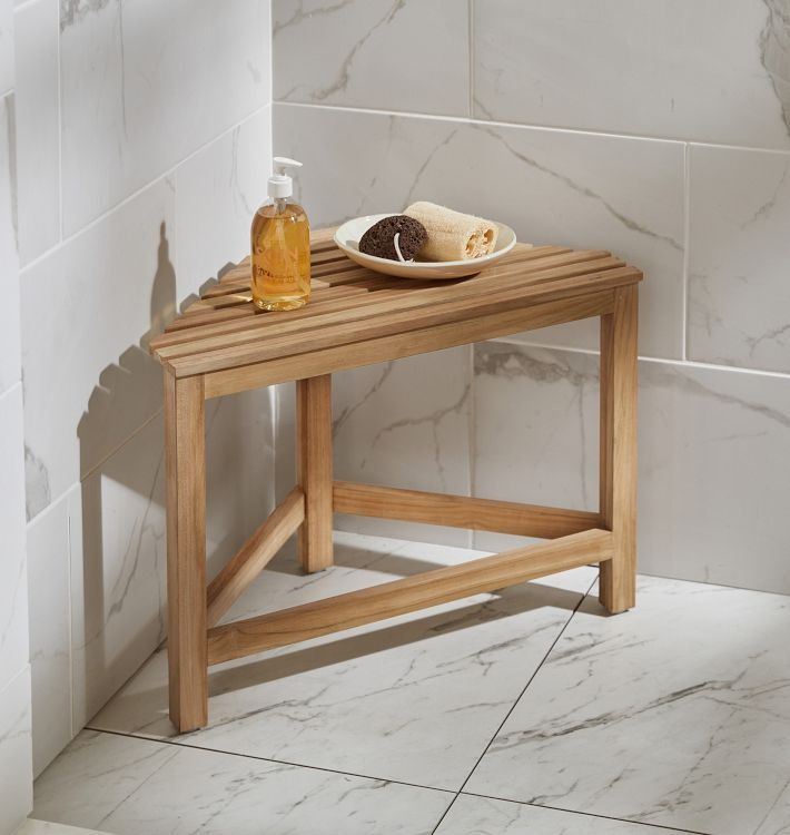 a wooden table with a plate of food on it next to a bathtub and shower