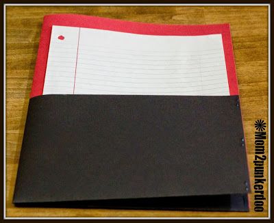 a black and red folder sitting on top of a wooden table