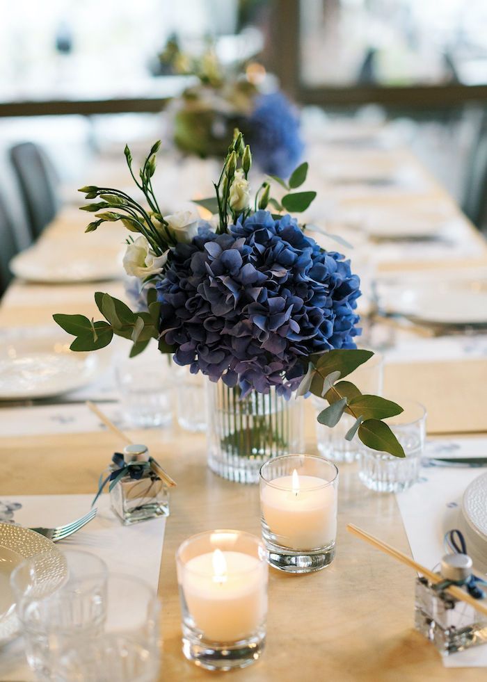 there is a vase with flowers and candles on the table