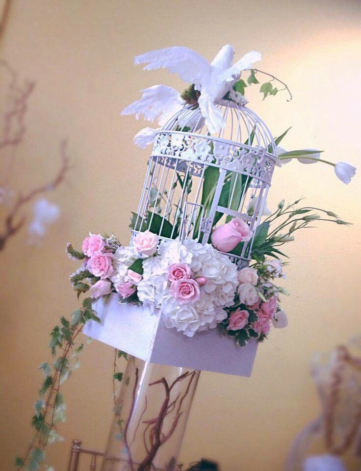 a birdcage with flowers and birds in it