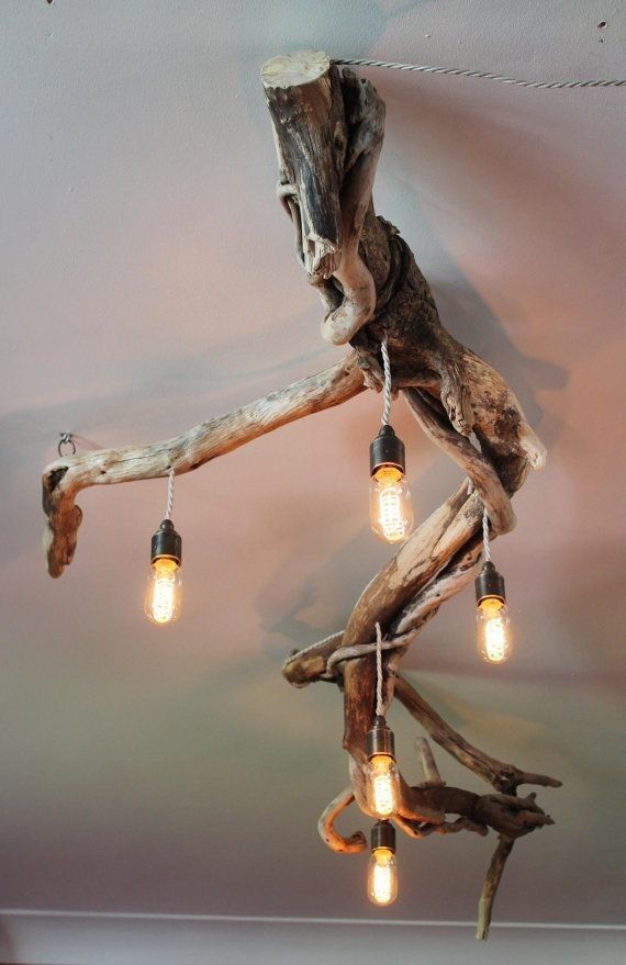 a light fixture made out of driftwood with bulbs hanging from it's end