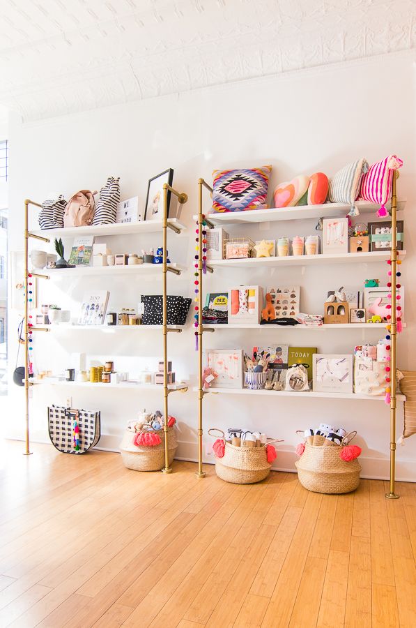 a room with shelves and baskets on the floor, all filled with crafting supplies