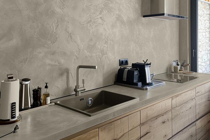 a kitchen counter with a sink and coffee maker