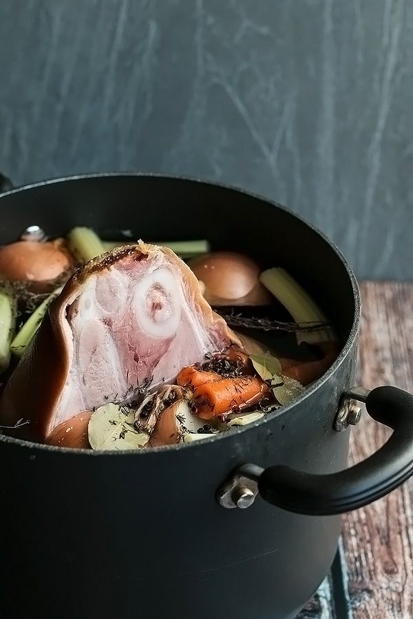 a pot filled with meat and vegetables on top of a wooden table