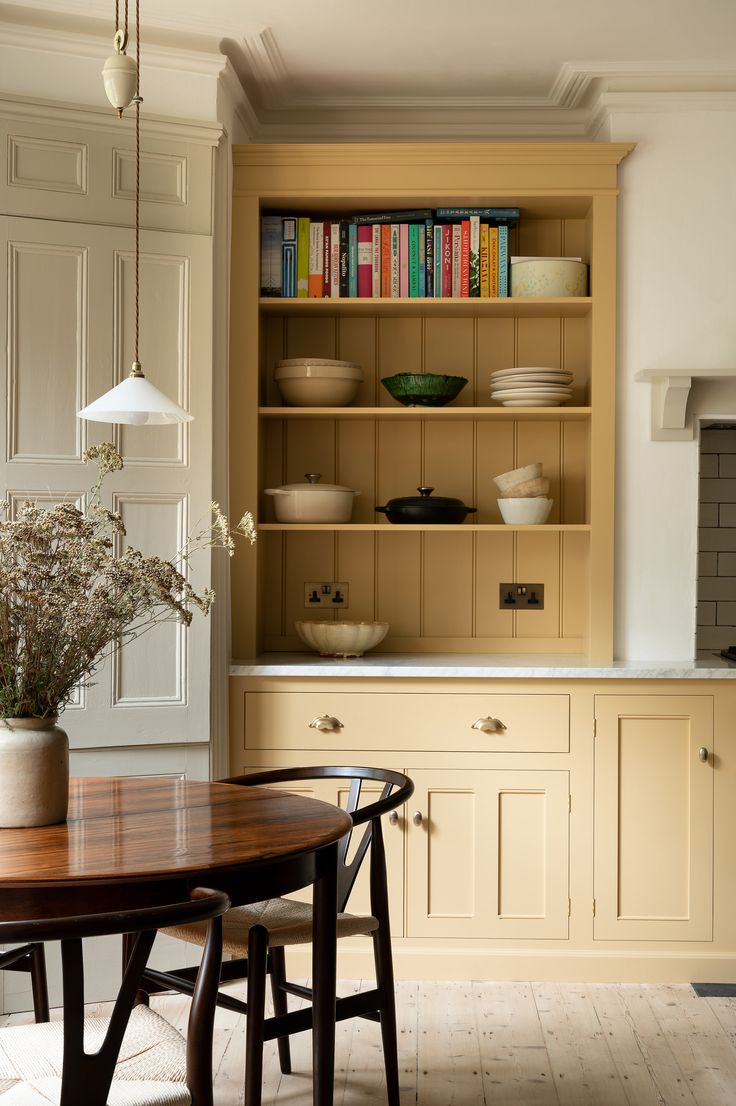 a table and chairs in a room with bookshelves