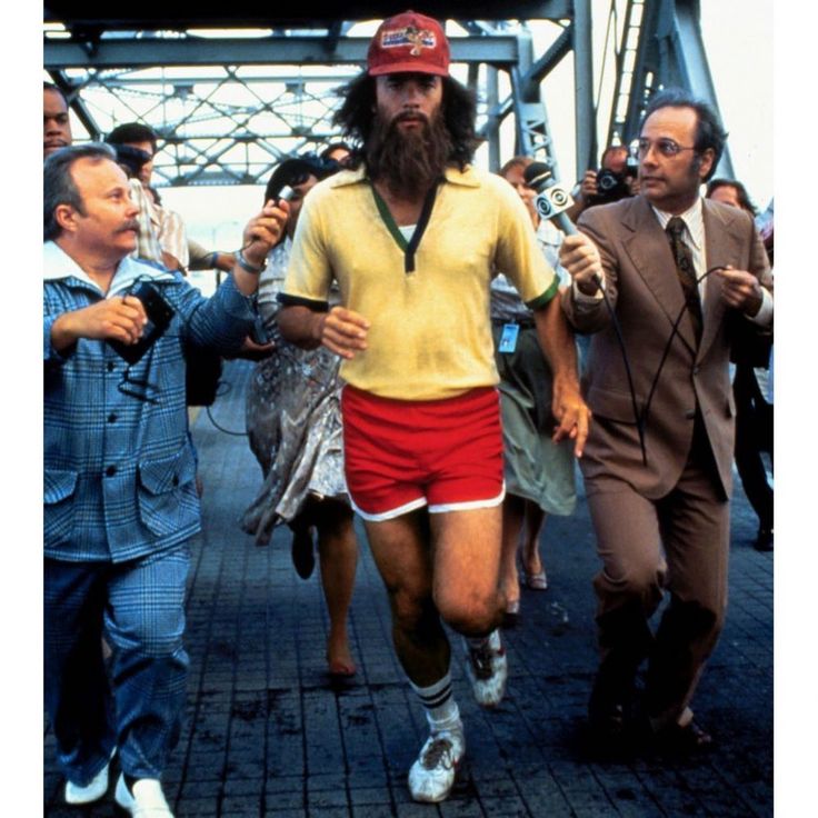 two men are walking down the street in shorts and t - shirts with long beards