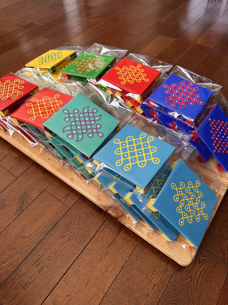 a wooden table topped with lots of different colored cards on top of plastic wrappers